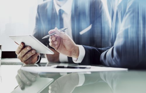 Corporate businessmen working on tablet at office